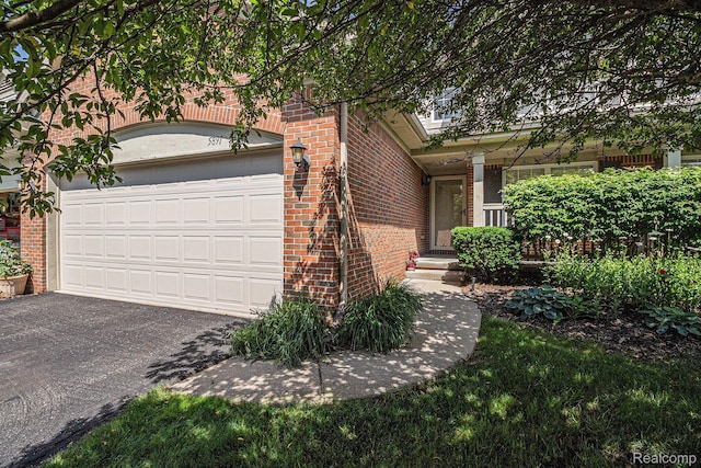 5891 Augusta Ln, Grand Blanc, MI 48439 - view of front of home with brick siding, an attached garage, and driveway