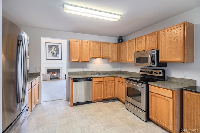 5891 Augusta Ln, Grand Blanc, MI 48439 - kitchen featuring stainless steel appliances, dark countertops, light floors, and a glass covered fireplace
