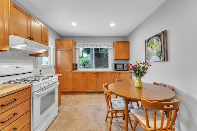 3622 Cushing Ct, Dexter, MI 48130 - kitchen featuring white gas range oven, under cabinet range hood, stainless steel microwave, light countertops, and recessed lighting