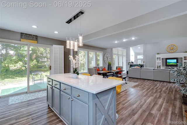 30753 Sunderland Dr, Farmington Hills, MI 48331 - kitchen featuring wood finished floors, a kitchen island, open floor plan, hanging light fixtures, and recessed lighting