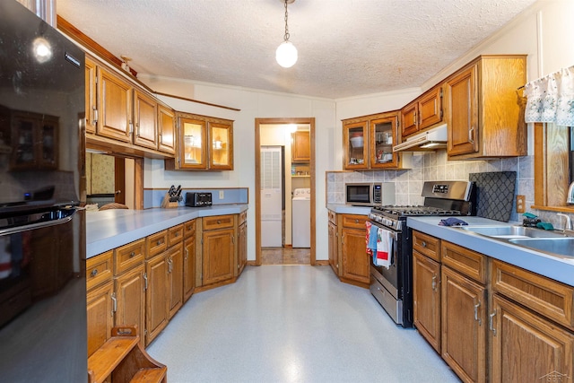 5665 N Sturgeon Rd, Midland, MI 48624 - kitchen with stainless steel appliances, washer / dryer, brown cabinets, a textured ceiling, and crown molding