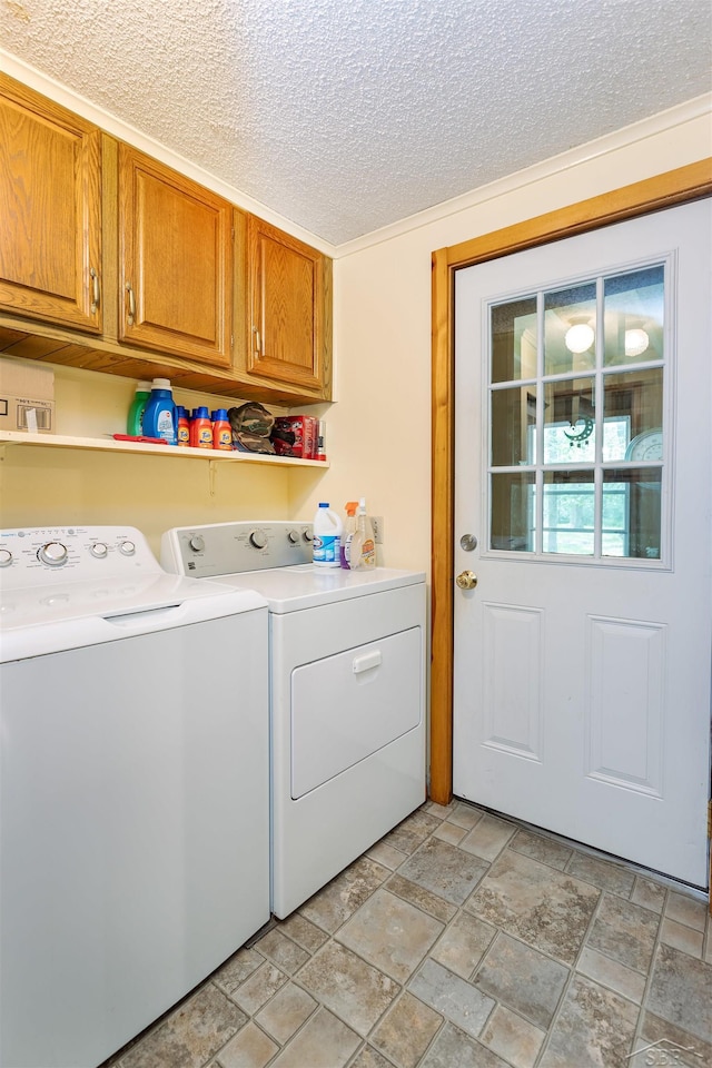 5665 N Sturgeon Rd, Midland, MI 48624 - laundry room featuring cabinet space, washing machine and dryer, a textured ceiling, and light stone finish flooring