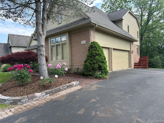 6601PEMBRIDGEHILL Pembridge Hl, West Bloomfield, MI 48322 - view of property exterior with brick siding, asphalt driveway, a garage, and a shingled roof