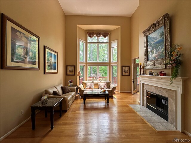 6601PEMBRIDGEHILL Pembridge Hl, West Bloomfield, MI 48322 - living room with a towering ceiling, a premium fireplace, light wood-type flooring, and baseboards