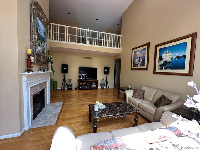 6601PEMBRIDGEHILL Pembridge Hl, West Bloomfield, MI 48322 - living area with baseboards, wood finished floors, a towering ceiling, and a tiled fireplace