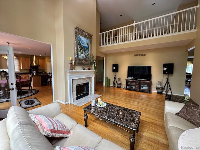 6601PEMBRIDGEHILL Pembridge Hl, West Bloomfield, MI 48322 - living area with a high ceiling, light wood-style flooring, baseboards, and a premium fireplace