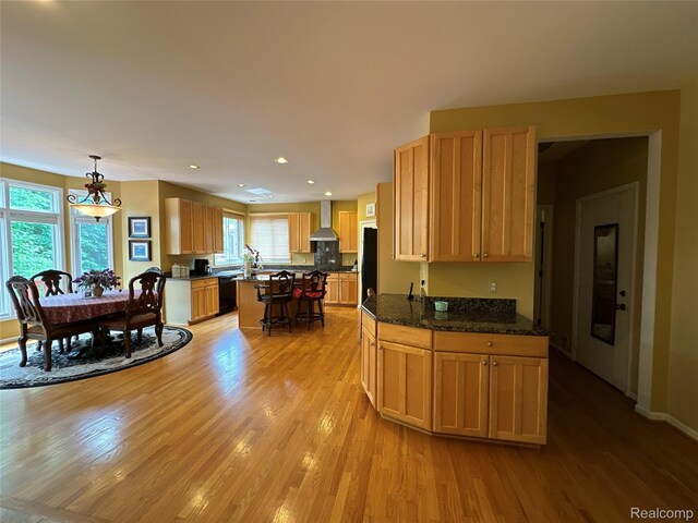 6601PEMBRIDGEHILL Pembridge Hl, West Bloomfield, MI 48322 - kitchen featuring black dishwasher, light wood finished floors, a kitchen island, freestanding refrigerator, and wall chimney range hood