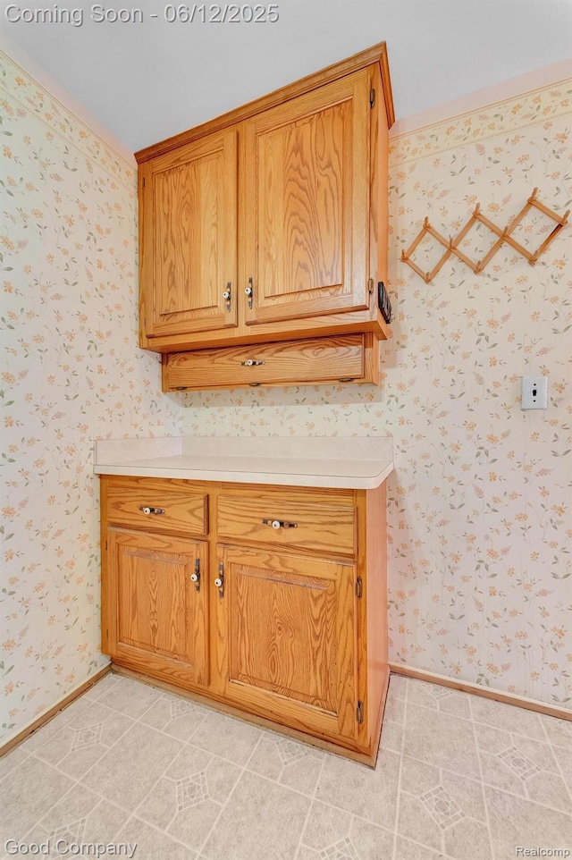 29628 Hoover Rd, Warren, MI 48093 - kitchen with light countertops, wallpapered walls, and brown cabinetry