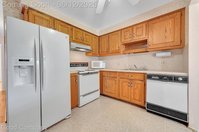 29628 Hoover Rd, Warren, MI 48093 - kitchen with white appliances, under cabinet range hood, light countertops, and brown cabinets