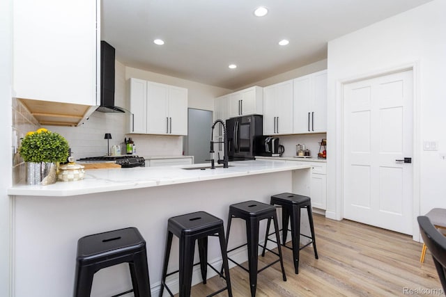 62874 Walker Ct Unit 17, Washington, MI 48094 - kitchen with a peninsula, range, black refrigerator, light wood-style floors, and backsplash