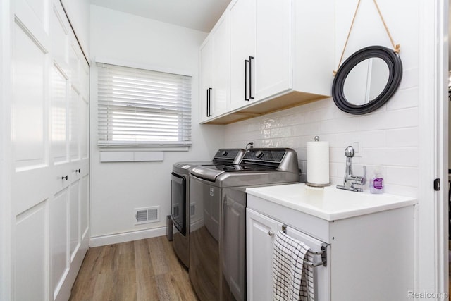 62874 Walker Ct Unit 17, Washington, MI 48094 - washroom with washer and clothes dryer, light wood-style floors, and cabinet space