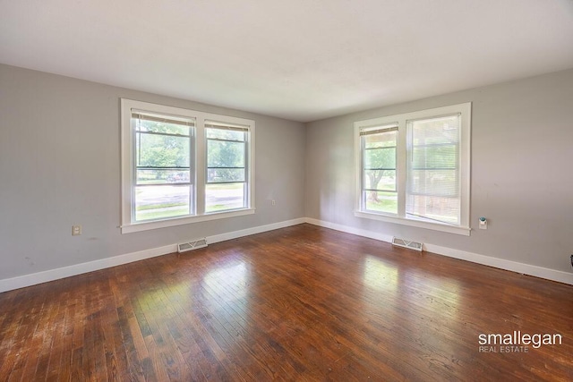 186 N Elm St, Sparta, MI 49345 - unfurnished room with healthy amount of natural light, dark wood-type flooring, and baseboards