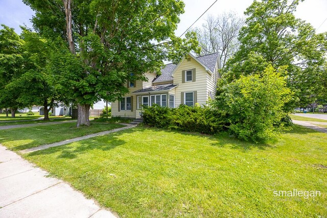 186 N Elm St, Sparta, MI 49345 - view of front facade featuring roof with shingles and a front yard