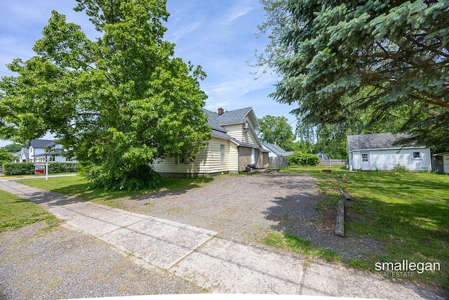 186 N Elm St, Sparta, MI 49345 - view of home's exterior with a yard, driveway, and a shingled roof