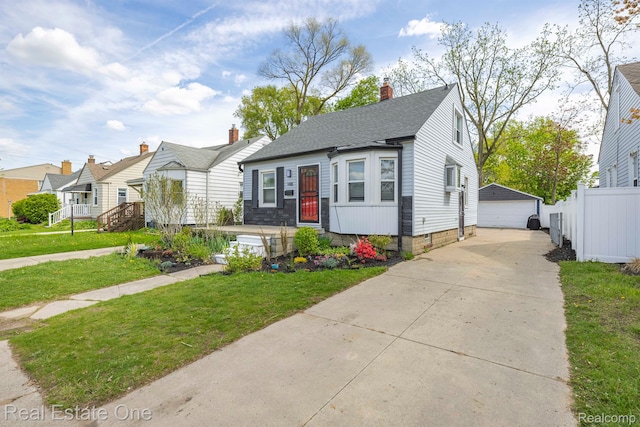 1418 E 10 Mile Rd, Ferndale, MI 48220 - bungalow-style home featuring a detached garage, an outbuilding, roof with shingles, and a chimney