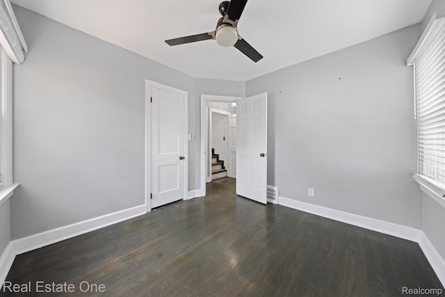 1418 E 10 Mile Rd, Ferndale, MI 48220 - unfurnished bedroom featuring multiple windows, baseboards, dark wood-style floors, and a ceiling fan