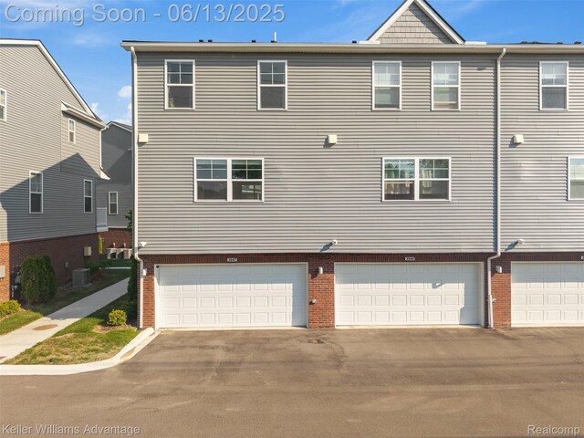 3947 Trailwaycommons Cir, Auburn Hills, MI 48326 - view of home's exterior featuring brick siding, an attached garage, and driveway