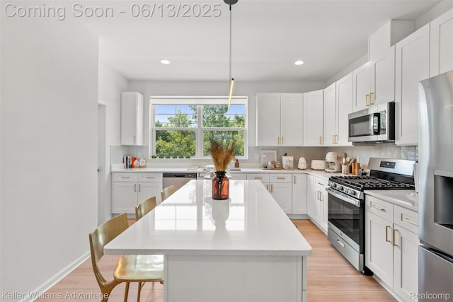 3947 Trailwaycommons Cir, Auburn Hills, MI 48326 - kitchen featuring appliances with stainless steel finishes, a kitchen island, backsplash, a breakfast bar, and white cabinetry
