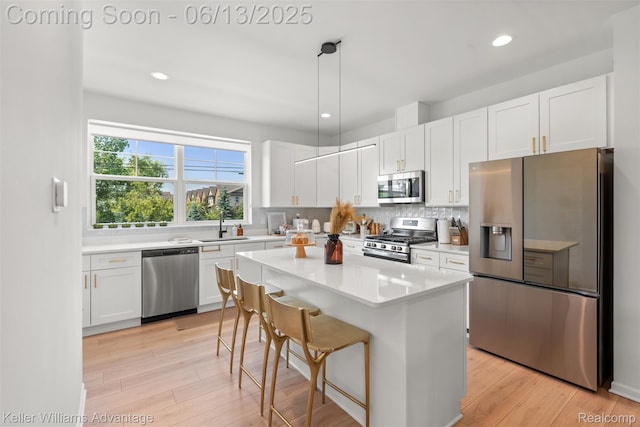 3947 Trailwaycommons Cir, Auburn Hills, MI 48326 - kitchen featuring appliances with stainless steel finishes, white cabinets, a kitchen bar, tasteful backsplash, and recessed lighting