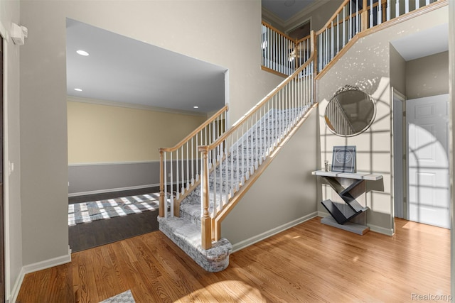 4991 Knollcrest Ct, Commerce Twp, MI 48382 - staircase featuring ornamental molding, wood finished floors, and a towering ceiling