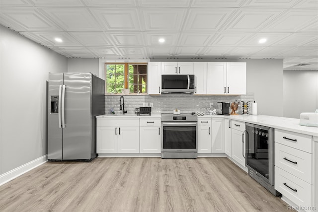4991 Knollcrest Ct, Commerce Twp, MI 48382 - kitchen featuring stainless steel appliances, beverage cooler, recessed lighting, backsplash, and white cabinetry
