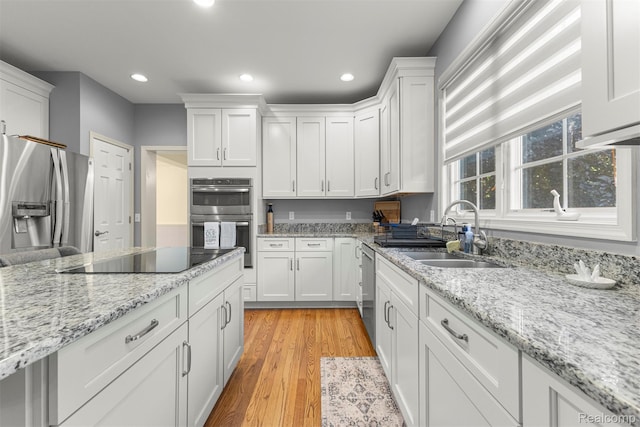 4991 Knollcrest Ct, Commerce Twp, MI 48382 - kitchen featuring stainless steel appliances, white cabinetry, light wood-style floors, recessed lighting, and light stone countertops