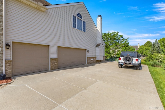 4991 Knollcrest Ct, Commerce Twp, MI 48382 - view of side of property with a garage, driveway, brick siding, and a chimney