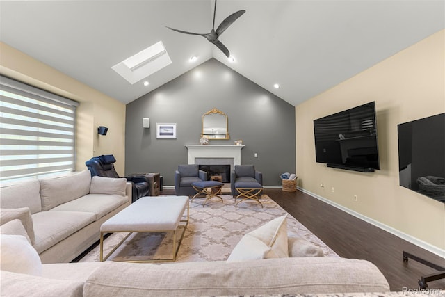 4991 Knollcrest Ct, Commerce Twp, MI 48382 - living area with a ceiling fan, a skylight, a fireplace, wood finished floors, and vaulted ceiling