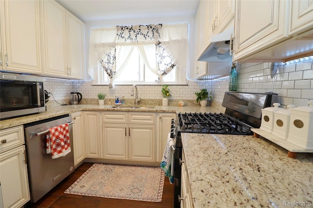 7524 Williamson St, Dearborn, MI 48126 - kitchen with appliances with stainless steel finishes, backsplash, light stone counters, cream cabinetry, and dark wood finished floors
