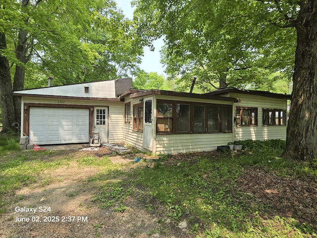 2327 W Midway Dr, White Cloud, MI 49349 - view of front of property with a sunroom, driveway, and a garage