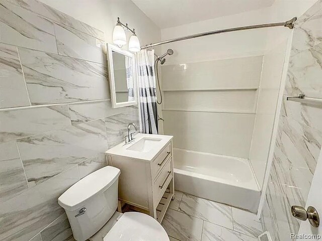 2454 Bellevue St, Saginaw, MI 48601 - full bathroom featuring toilet, shower / tub combo, marble look tile flooring, vanity, and tile walls