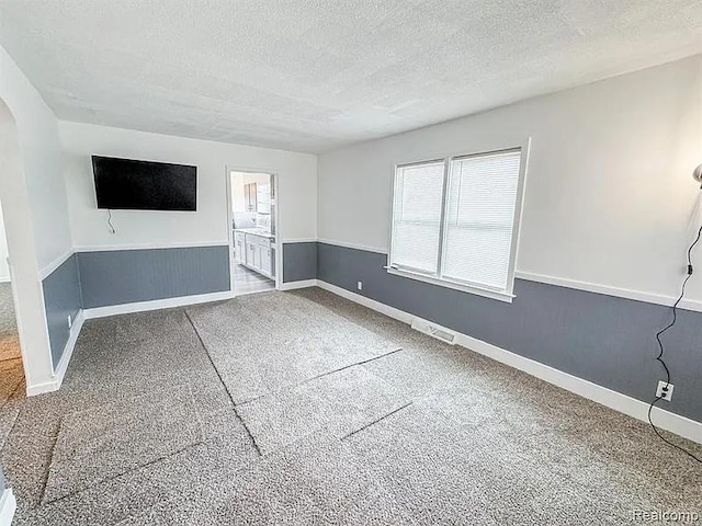 2454 Bellevue St, Saginaw, MI 48601 - unfurnished living room with a textured ceiling, carpet, and baseboards