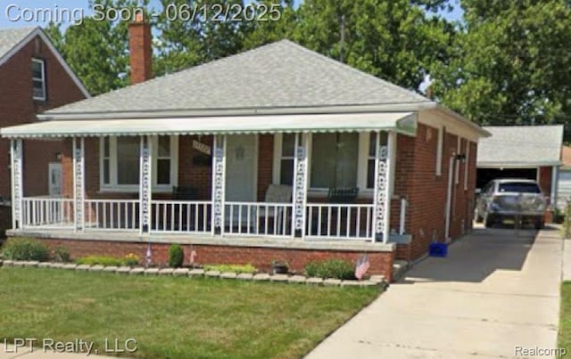 13522 Callender St, Southgate, MI 48195 - view of front of home with covered porch, a chimney, brick siding, concrete driveway, and a front lawn