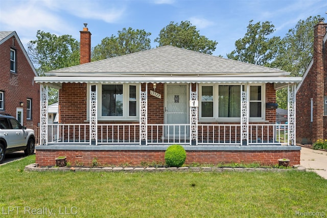 13522 Callender St, Southgate, MI 48195 - bungalow-style house with a porch, a chimney, a front lawn, and roof with shingles