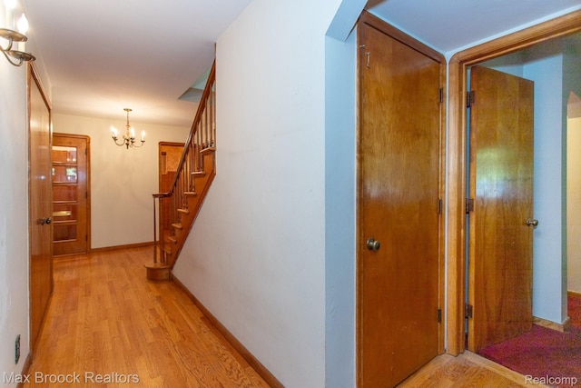 25695 York Rd, Royal Oak, MI 48067 - hallway featuring light wood-style floors, a chandelier, stairway, and arched walkways