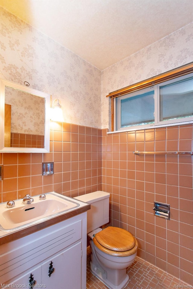 25695 York Rd, Royal Oak, MI 48067 - half bath with wallpapered walls, tile walls, and vanity
