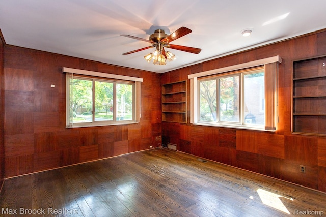 25695 York Rd, Royal Oak, MI 48067 - spare room featuring wooden walls, built in features, wood-type flooring, and a ceiling fan