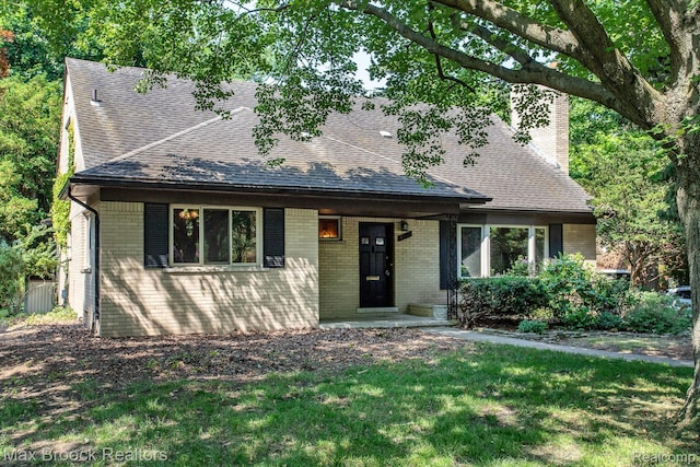 25695 York Rd, Royal Oak, MI 48067 - view of front facade with roof with shingles, a chimney, brick siding, and a front lawn
