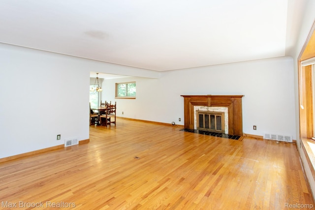 25695 York Rd, Royal Oak, MI 48067 - unfurnished living room with light wood-style flooring, a chandelier, and a premium fireplace
