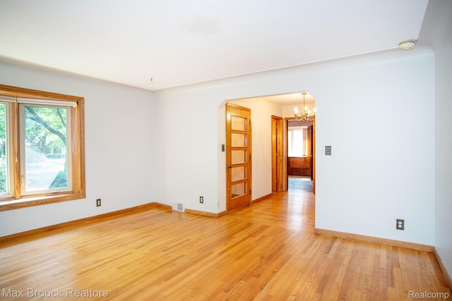 25695 York Rd, Royal Oak, MI 48067 - spare room featuring a chandelier, a smoke detector, light wood-type flooring, and arched walkways