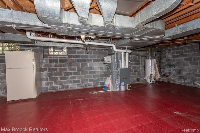 25695 York Rd, Royal Oak, MI 48067 - unfinished below grade area featuring freestanding refrigerator, water heater, tile patterned floors, and heating unit