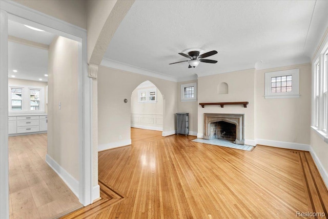 16525 Roselawn St, Detroit, MI 48221 - unfurnished living room featuring light wood finished floors, a fireplace with flush hearth, ceiling fan, baseboards, and a textured ceiling