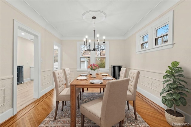 16525 Roselawn St, Detroit, MI 48221 - dining space featuring a chandelier, light wood-type flooring, wainscoting, and crown molding