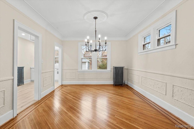 16525 Roselawn St, Detroit, MI 48221 - unfurnished dining area featuring radiator, a chandelier, light wood-style floors, crown molding, and wainscoting