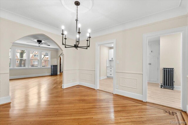 16525 Roselawn St, Detroit, MI 48221 - unfurnished dining area featuring arched walkways, a chandelier, light wood-type flooring, ornamental molding, and radiator