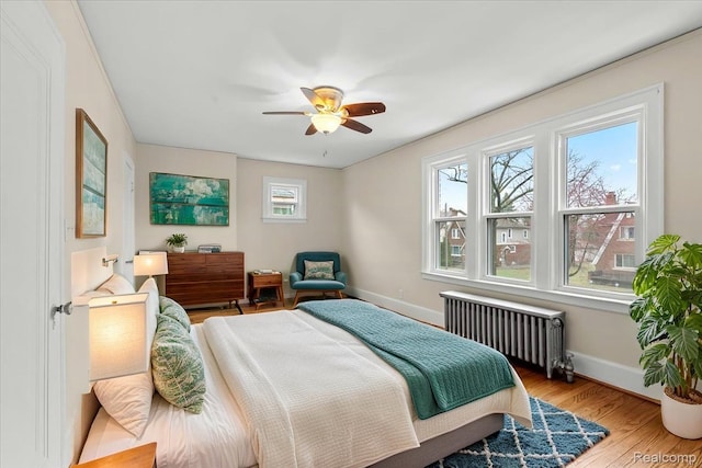 16525 Roselawn St, Detroit, MI 48221 - bedroom featuring radiator heating unit, baseboards, wood finished floors, and a ceiling fan