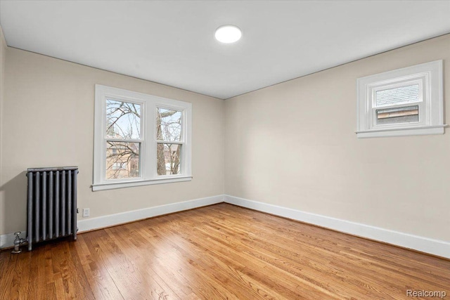 16525 Roselawn St, Detroit, MI 48221 - spare room featuring radiator, baseboards, and wood finished floors