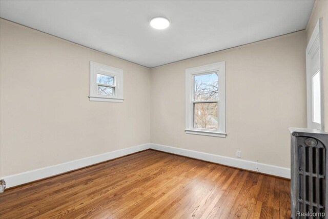 16525 Roselawn St, Detroit, MI 48221 - unfurnished room featuring radiator, baseboards, healthy amount of natural light, and light wood-type flooring