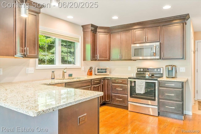 43543 Abbey Cir, Canton, MI 48187 - kitchen with appliances with stainless steel finishes, light stone counters, a peninsula, light wood finished floors, and recessed lighting