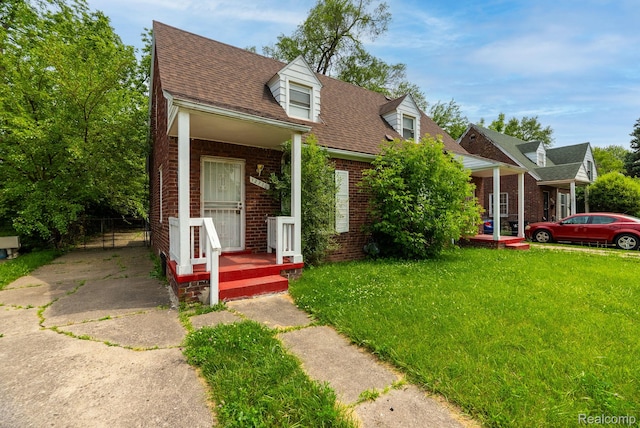 12702-12710 Kelly Rd, Detroit, MI 48224 - cape cod-style house with brick siding, a front lawn, roof with shingles, and a porch